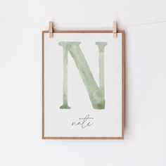 the letter n is made up of watercolor paper and hangs on a clothes line