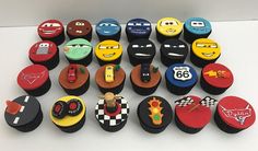 many cupcakes are decorated with cars and race symbols on them, all in different colors