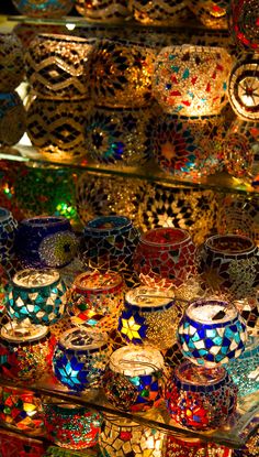 there are many colorful glass bowls on display