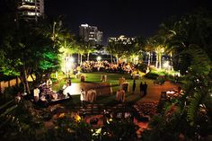 an outdoor wedding reception in the city at night