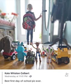 a little boy standing in front of a bunch of toys