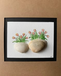 two seashells with flowers in them on a card