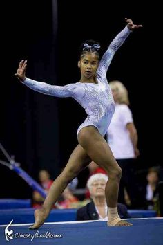 a young woman is performing on the balance beam