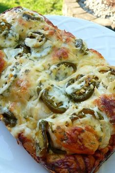 a slice of pizza on a white plate with cheese and green peppers in the crust