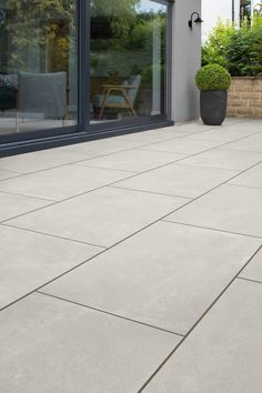 an outdoor patio with potted plants on the side and sliding glass doors leading outside