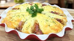 a pie with ham and cheese in a red dish on a wooden table top,