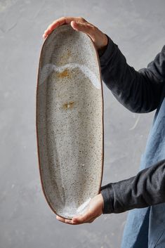 a person holding a white plate with speckles on it