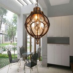 a light fixture hanging from the ceiling in a room with chairs and tables around it