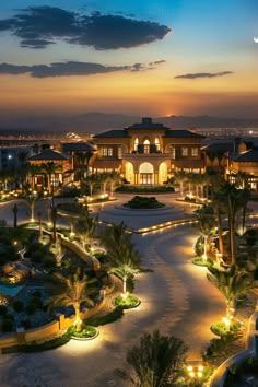 an aerial view of a resort at night with lights on the walkway and palm trees