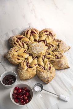 cranberry danish pastries with powdered sugar and cherries in small bowls