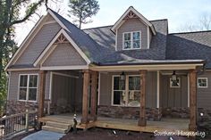 a house that is made out of wood and has stone on the front porch, and covered in shingles