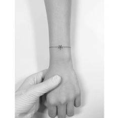 a woman's wrist with a tiny cross on it