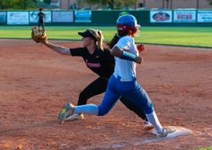 two women playing baseball on a field during the day, one is running to catch the ball