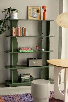 a living room filled with furniture and bookshelves next to a table in front of a window