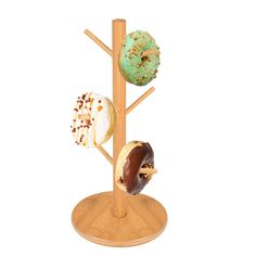 three donuts are on a wooden stand and one is in the shape of a tree