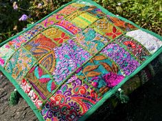 a colorful patchwork pillow sitting on top of a rock