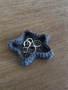 a small crocheted star with scissors in it on a table next to a pair of eyeglasses