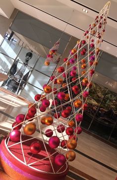 a sculpture in the shape of a spiral with red and orange balls