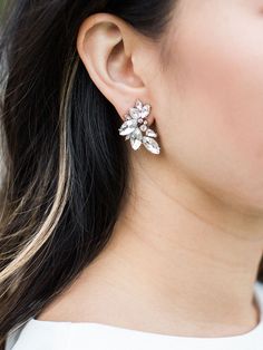 a close up of a woman wearing earrings with flowers on it's back end