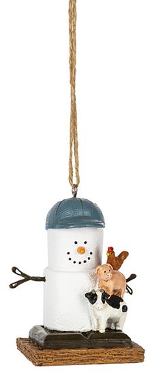 a christmas ornament with a snowman and a cow hanging from it's side