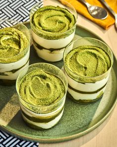 four glasses filled with green powder on top of a plate