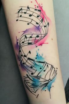 a watercolor tattoo with musical notes painted on it's arm and the word music