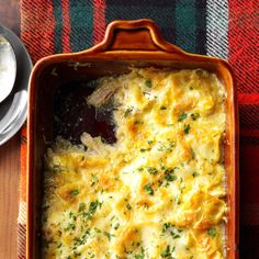 a casserole dish with cheese and broccoli in it on a table