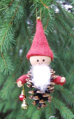 an ornament hanging from a pine cone with a gnome on it's back