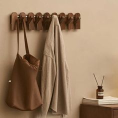 a coat rack with two coats hanging from it's sides next to a table