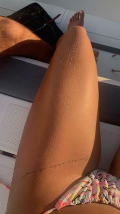 there is a woman laying down on the back of a boat with her legs crossed