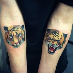 two people with tattoos on their arms, one has a tiger and the other has a bear