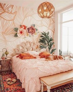 a cat laying on top of a bed in a room with floral wallpaper and rugs