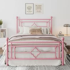 a pink metal bed frame in a white bedroom