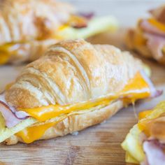 croissants with ham and cheese are on a cutting board