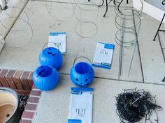 three blue pumpkins sitting on the ground next to each other with wires attached to them