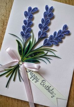 a birthday card with blue flowers on it and a ribbon tied around the edge that says happy birthday