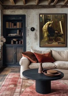 a living room filled with furniture and a painting on the wall