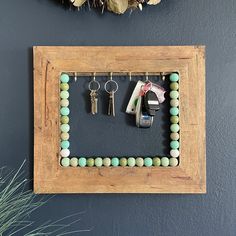 a wooden frame with beads and keys hanging on it