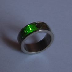 a ring with green lights on it sitting on a white surface, showing the inside of the ring