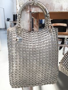 a silver purse sitting on top of a wooden table