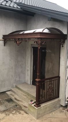 a gazebo sitting on the side of a building next to a door and steps