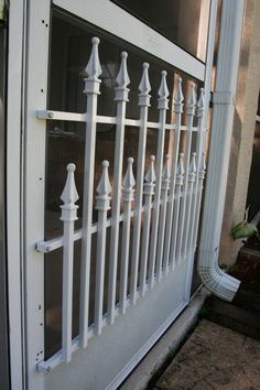 a white iron fence sitting next to a window