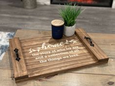 a wooden tray with some writing on it and a potted plant next to it