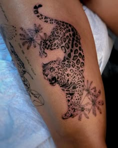 a tattoo on the arm of a woman with a cheetah and flower design