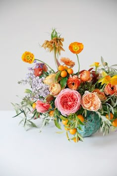 a vase filled with lots of different colored flowers