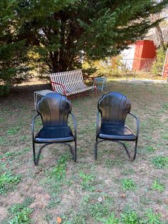 two chairs sitting on top of a grass covered field