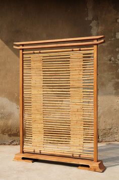 a wooden frame sitting on top of a cement floor next to a wall with a window