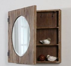 an open wooden cabinet with mirror and seashells