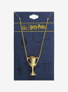 a necklace with a golden cup on it in front of a blue cardboard background