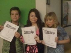 three people holding up some papers with the words icarly written on them in front of them